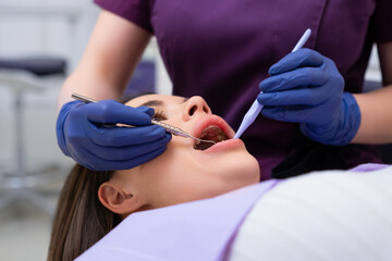 A dentist is inspecting a patients teeth during an appointment at the dental clinic