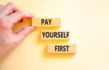 Pay yourself first symbol. Concept words Pay yourself first on beautiful wooden blocks. Beautiful white table white background. Businessman hand. Business and pay yourself first concept. Copy space.