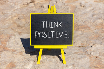 Think positive symbol. Concept words Think positive on beautiful black chalk blackboard. Beautiful...