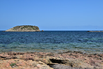rock beach with small rock island in the background