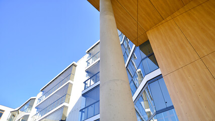 Obraz premium A apartment building with a unique architectural solution. A modern residential building with a white facade and standing on high concrete pillars.