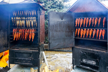 Opened smokehouses with fresh hot-smoked red sea bass and mackerels