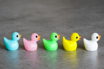Various colors miniature toy ducklings in a row, diversity, equality and inclusion concept