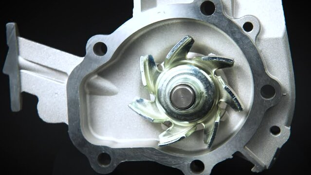 Close-up Water pump of the internal combustion engine cooling system. new engine part on a black background