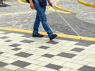 A visually disabled person uses a road safety floor sign
