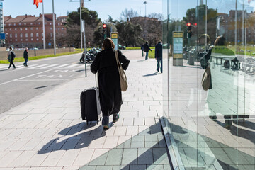 Woman with suitcases at the exit of the Bus Station. Pamplona, ​​Navarra