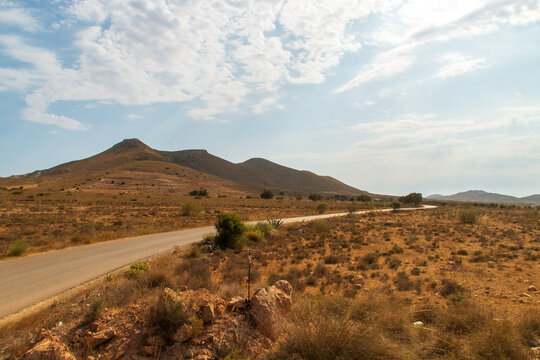Carretera secundaria que discurre en un paisaje desértico en un caluroso día de verano. Carretera que une Agua Amarga con la pedanía Fernán Pérez en Almería, España.