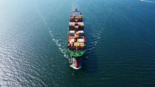 Large loaded Container ship cruising across sea, Aerial view