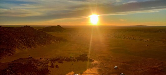 Panoramic sunset view from Timimoun, Algeria, overlooking the red sand desert and canyons from a hilltop. - obrazy, fototapety, plakaty