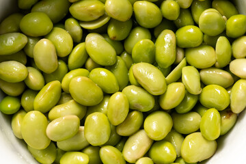 cooked edamame beans on bright background