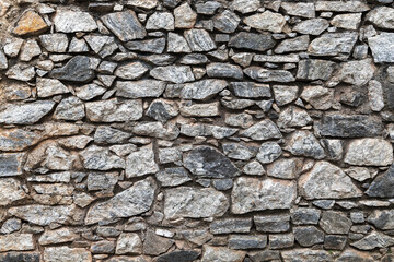 Old dark gray stone wall, background photo texture