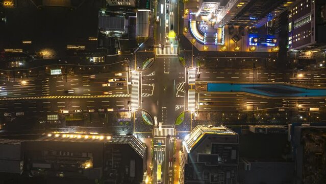 Top down ascending hyperlapse footage of traffic on road intersection in city at night. Vehicles passing through crossroads. Kyoto, Japan