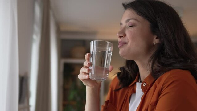 woman beautiful young female stand at home with glass of water drink