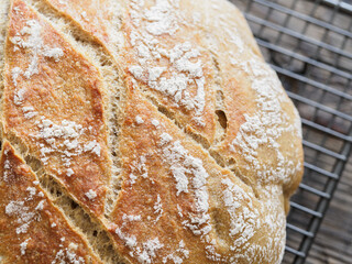Artisan bread with a dusting of flour on a cooling rack.