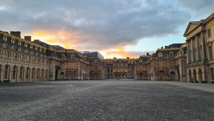 Fototapeta na wymiar Le château de Versailles vu depuis le Portail au coucher du soleil
