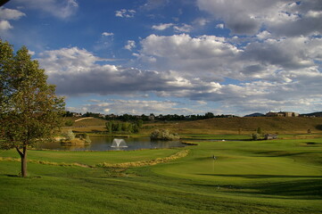 Fototapeta na wymiar the fairgrounds of a golf course near a pond with water and grass