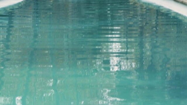 Fonte antiga, no meio de uma avenida de cidade movimentada. a fonte tem uma estatua de onde a agua desce e forma um lago de agua muito azul e brilhante. Ouve-se a agua a cair e carros ao fundo