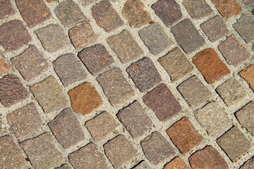 Old road made of cobblestones and stones. Vintage masonry background