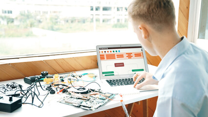 Caucasian student looking at laptop screen while coding engineering prompt or programing system....