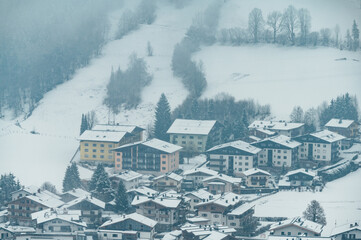 Fototapeta na wymiar heavy snowfall in a ski resort in Austria, big snowflakes, houses covered with snow 