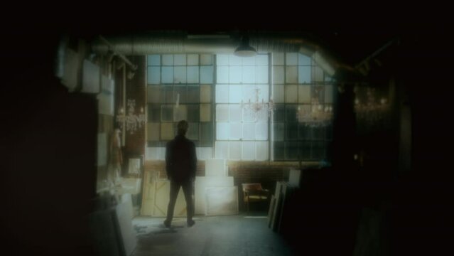 Painter Inside Studio Alone Looking Window Tracking Shot. Silhouette of a male artist standing alone inside a studio. Tracking shot