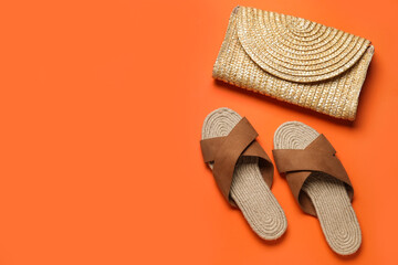 Stylish brown sandals and wicker bag on orange background