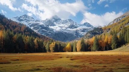 Obraz premium A serene autumn landscape filled with lush trees and towering mountains, surrounded by a vast wilderness and painted with vibrant clouds in the sky