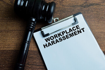 Concept of Workplace Harassement write on paperwork with gavel isolated on wooden background.