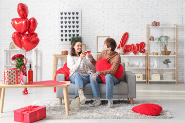 Young couple with glasses of wine having date at home. Valentine's day celebration