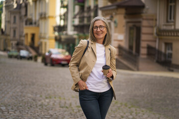 Fototapeta premium A woman walking down a cobblestone street in an urban setting.