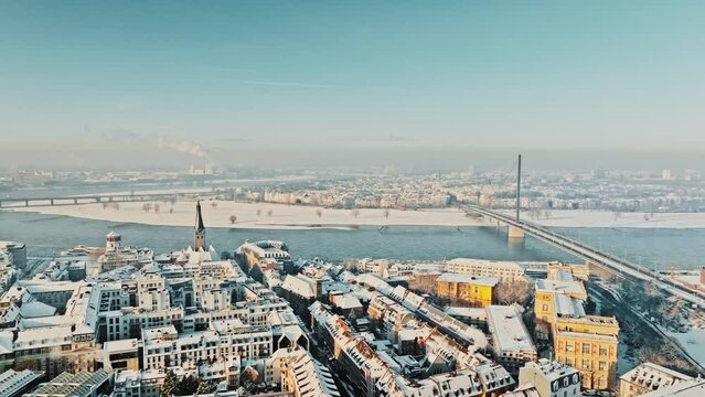 Drone sightseeing flight over snowy winter city of Düsseldorf with view of Rhine on sunny morning