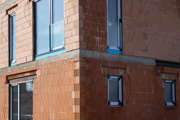 facade of a new private house built with modern red clay ceramic bricks before insulation works....