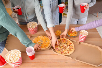 Group of young friends with beer and pizza at home party, closeup
