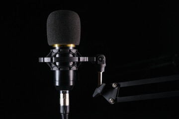Studio microphone for podcast and voice recording on a black background with space for inscription