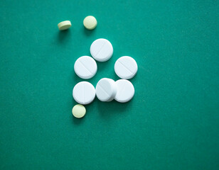 a handful of pills on a green background. Addiction, pills, viruses