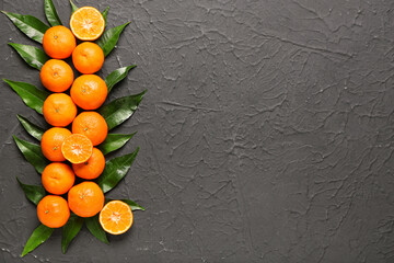 Sweet mandarins and leaves on black background