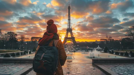 Fotobehang A mesmerizing sunset illuminates a woman gazing at the majestic eiffel tower, its reflection dancing on the tranquil waters as the city awakens to a new day © ChaoticMind