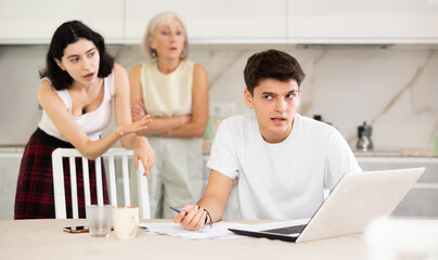 Fototapeta premium Mom and young wife scold her husband about financial problems. Husband is not satisfied with the calculations of financial results