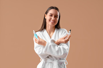 Young woman with remedies for hair loss treatment on beige background