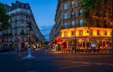 Cozy street with tables of cafe in Paris, France. Night cityscape of Paris. Architecture and landmarks of Paris. - 741053413