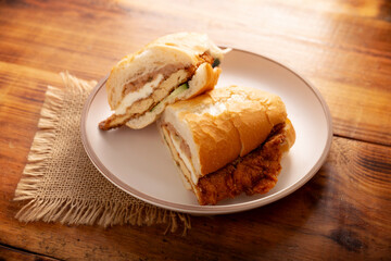 Mexican Torta de Milanesa. Sandwich made with bolillo bread, telera or baguette, split in half and filled with various ingredients, in this case breaded chicken meat with Oaxaca cheese.