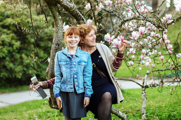 grandmother and granddaughter are happy of magnolia blossoms