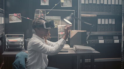 Young investigator using 3d vr headset in incident room, using interactive virtual reality glasses to uncover new clues. Police agent checking forensic evidence and doing detective work. - obrazy, fototapety, plakaty