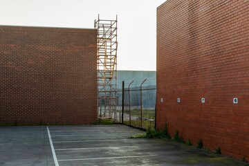 Metal Fire Escape Staircase Outside Industrial Building, with Parking Area