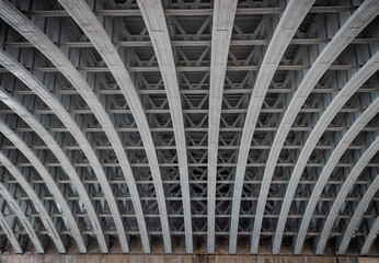 View of Structure and beams under the Curved steel Bridge. Framework metal arches girder...
