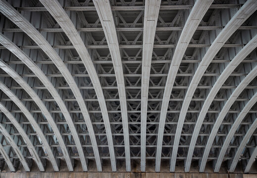 View of Structure and beams under the Curved steel Bridge. Framework metal arches girder construction Underneath of Blackfriars Bridge, Riveted steel beams supporting bridge span, Space for text, Sele