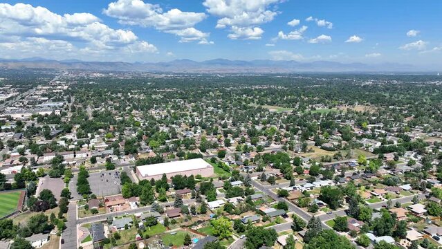 Lakewood, Colorado - Aerial drone video of North Alameda neighborhood in Lakewood with the Rocky Mountains in the distance on a summer day