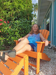 senior adult woman sitting in Adirondack Chair