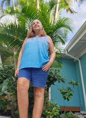 senior adult woman standing in front of house