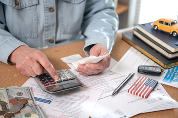 Individual income tax return. Woman work with financial papers at home count on calculator before paying taxes receipts.